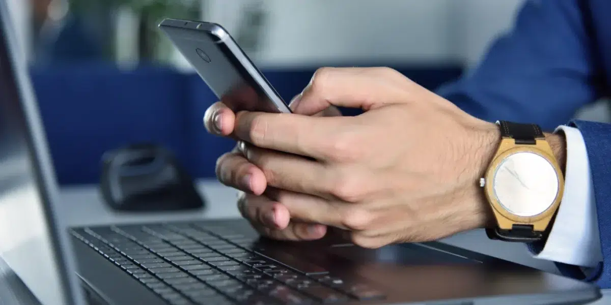 close up of man texting on phone utilizing healthy internet habits and high speed internet upload speed.