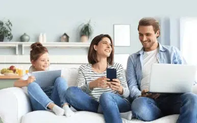 image of family using devices discussing the four benefits of fiber internet.