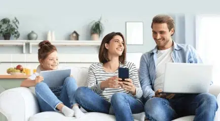 image of family using devices discussing the four benefits of fiber internet.