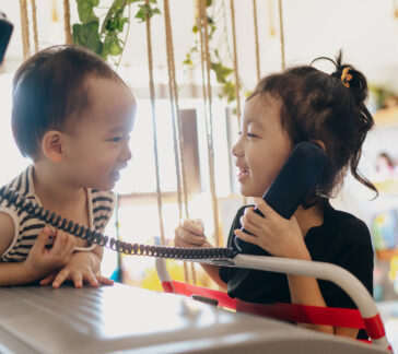 two small children talking on the phone