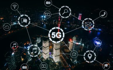 A night aerial view of a city with illuminated buildings and digital icons connected by lines, centered around the '5G' symbol. This image illustrates the wide-reaching capabilities of 5G technology for home internet and various connected services. What is 5g home internet?