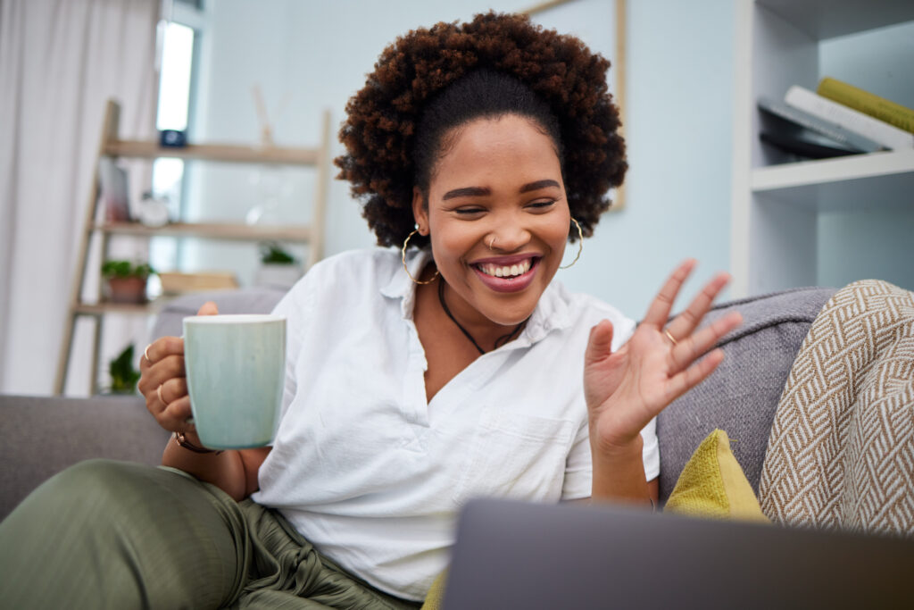 A woman enjoying a video call from her laptop at home, wondering how much internet speed do I need to maintain a clear and stable connection.