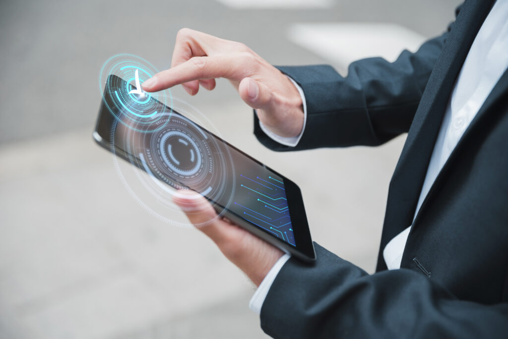 A business professional interacting with a tablet, with holographic icons and circuits representing advanced digital communication, showcasing the technological differences between fiber optic internet vs cable.